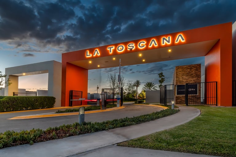 Modern La Toscana restaurant storefront with bold orange facade, neon signage, and evening sky backdrop