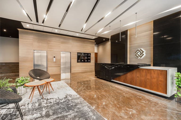 Modern office lobby with wood-paneled walls, reception desk, minimalist seating area, and contemporary ceiling design