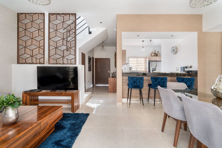 Modern open-plan living and dining space with wooden furniture, blue accents, and contemporary decor throughout the room
